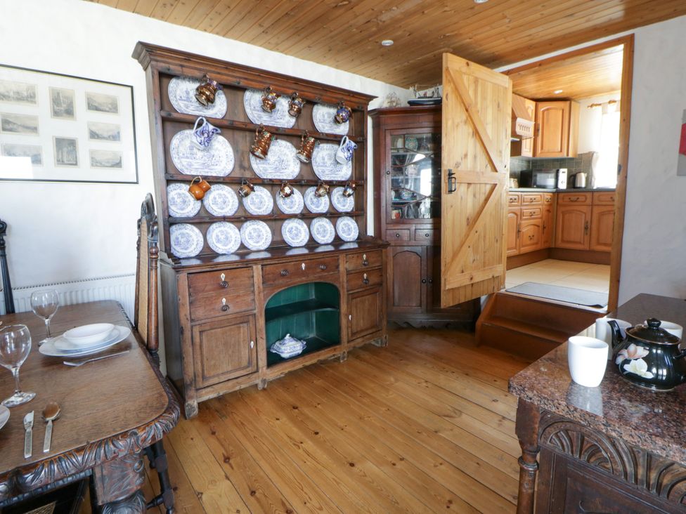 A kitchen with wooden furniture and glassware at Harbour High Annex in Fishguard