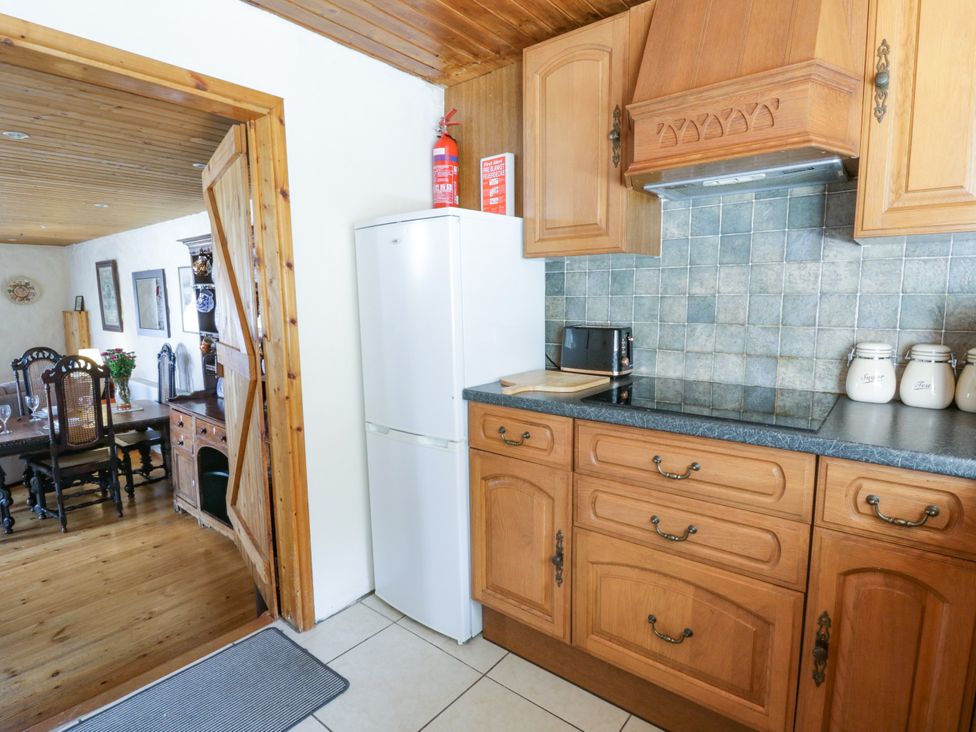 A kitchen with fridge, microwave, and cabinets at Harbour High Annex in Fishguard
