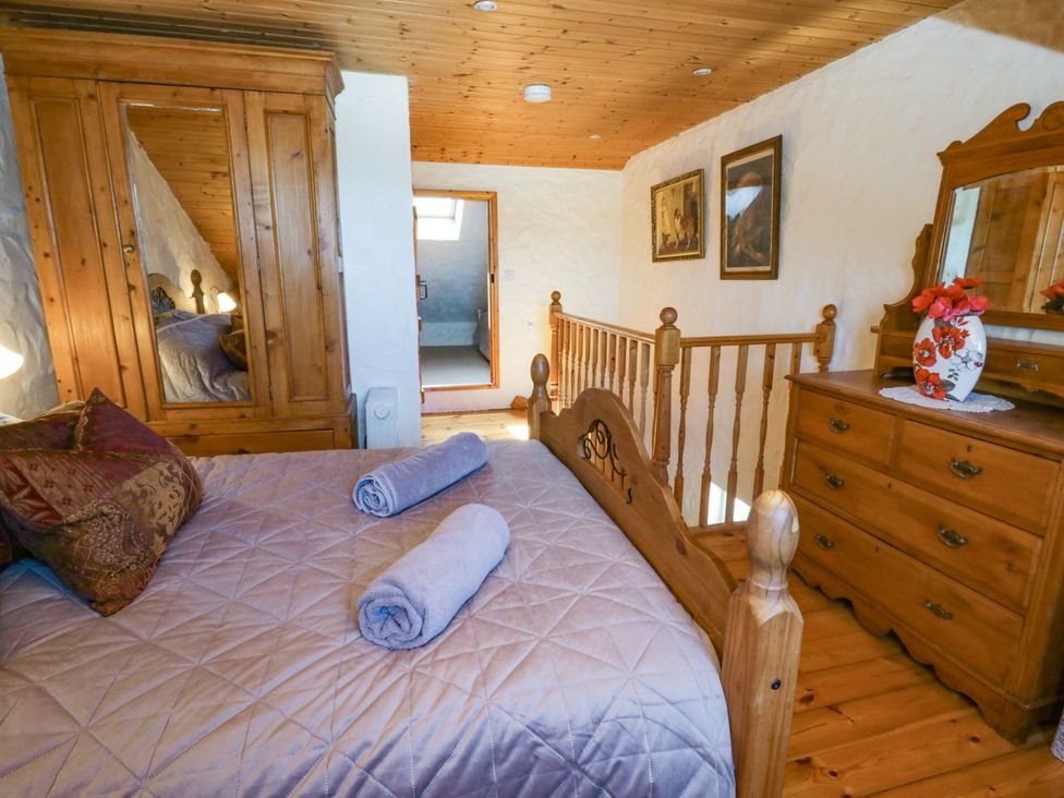 A bedroom with a bed and wardrobe at Harbour High Annex in Fishguard