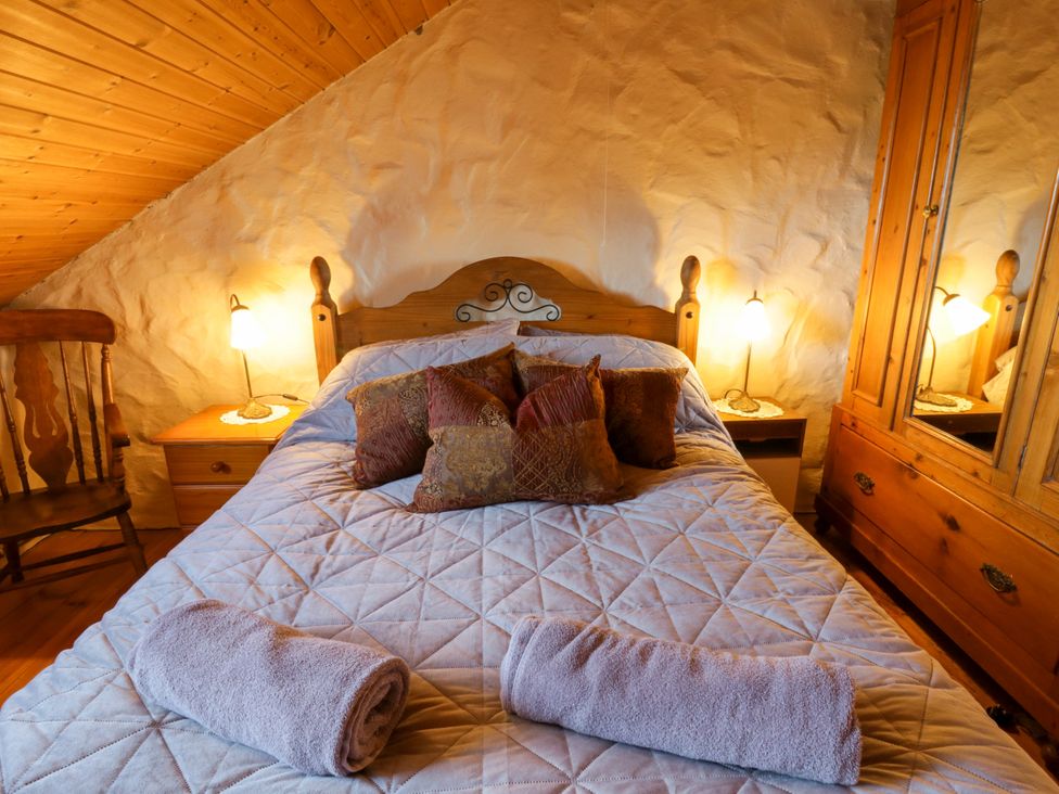 A bedroom with a double bed and wooden furniture at Harbour High Annex in Fishguard