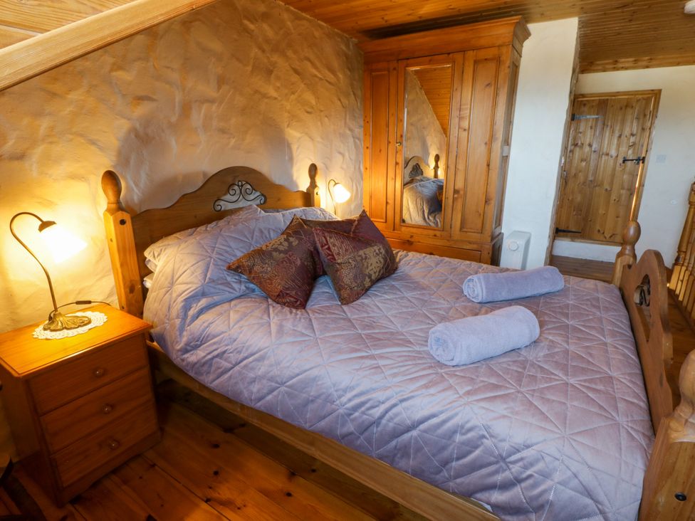 A bedroom with a bed and wardrobe at Harbour High Annex Fishguard