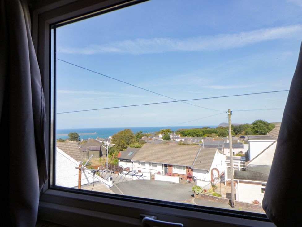 A view of the sea and houses from a window at Harbour High Annex in Fishguard