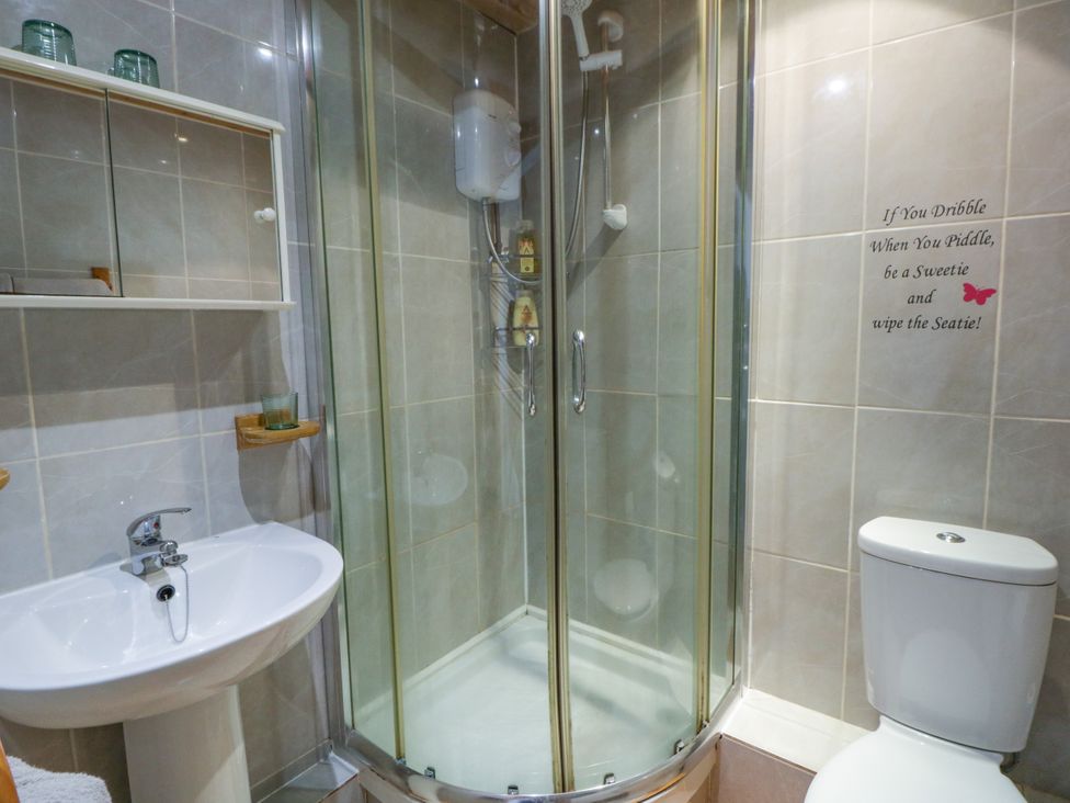 A bathroom with a shower, toilet, and sink at Harbour High Annex in Fishguard