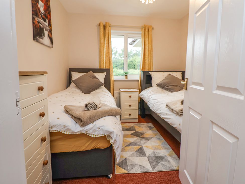 A bedroom with two beds and a window at 2 Mountain View in Chirk
