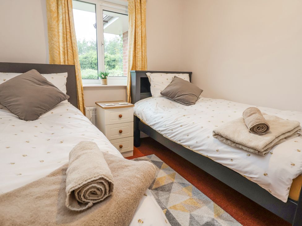 A bedroom with two beds and a side table at 2 Mountain View, Chirk