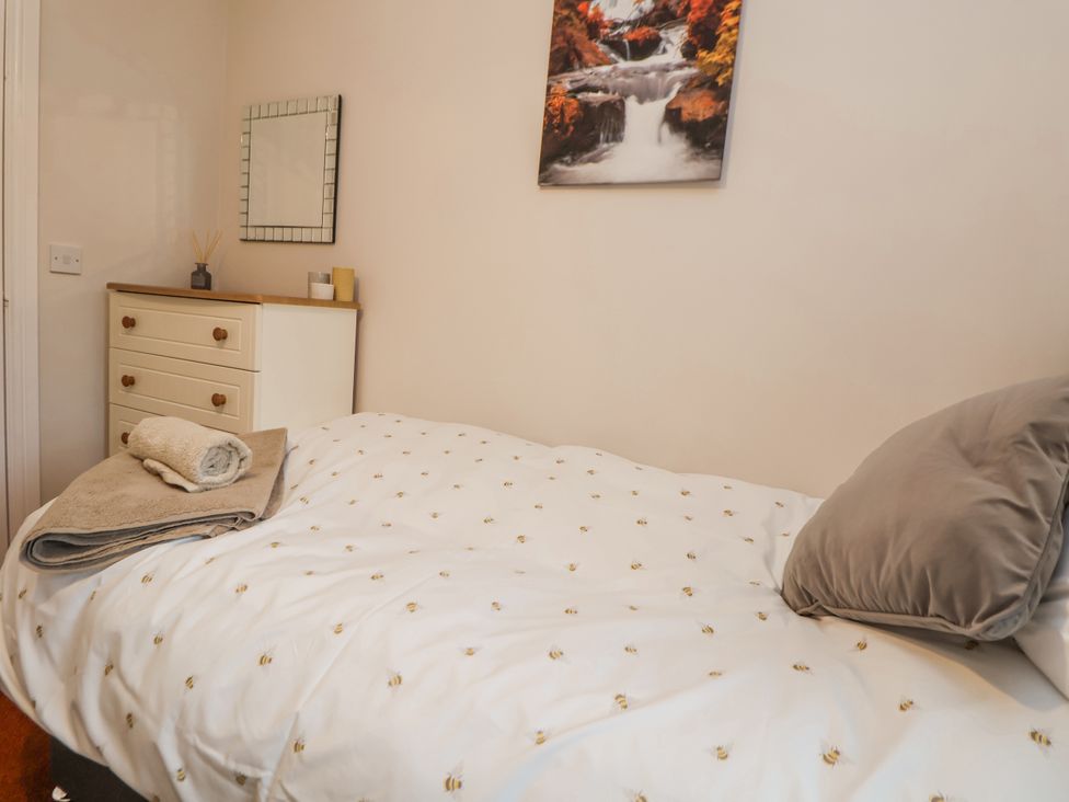 A bedroom with a bed and dresser at 2 Mountain View in Chirk