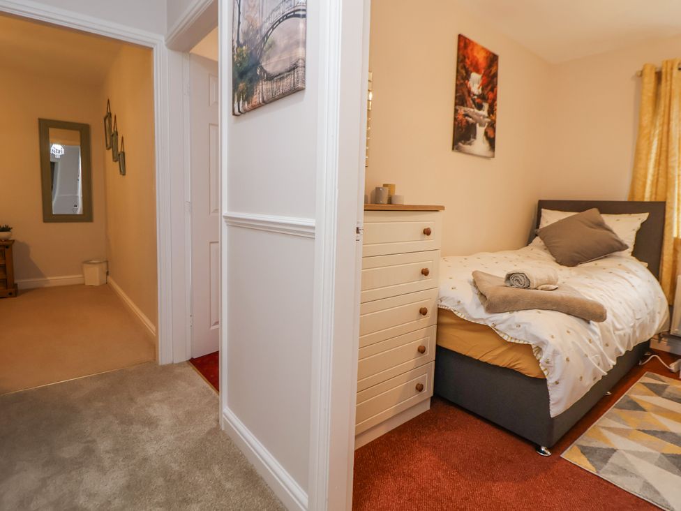 A bedroom with a bed and dresser at 2 Mountain View in Chirk