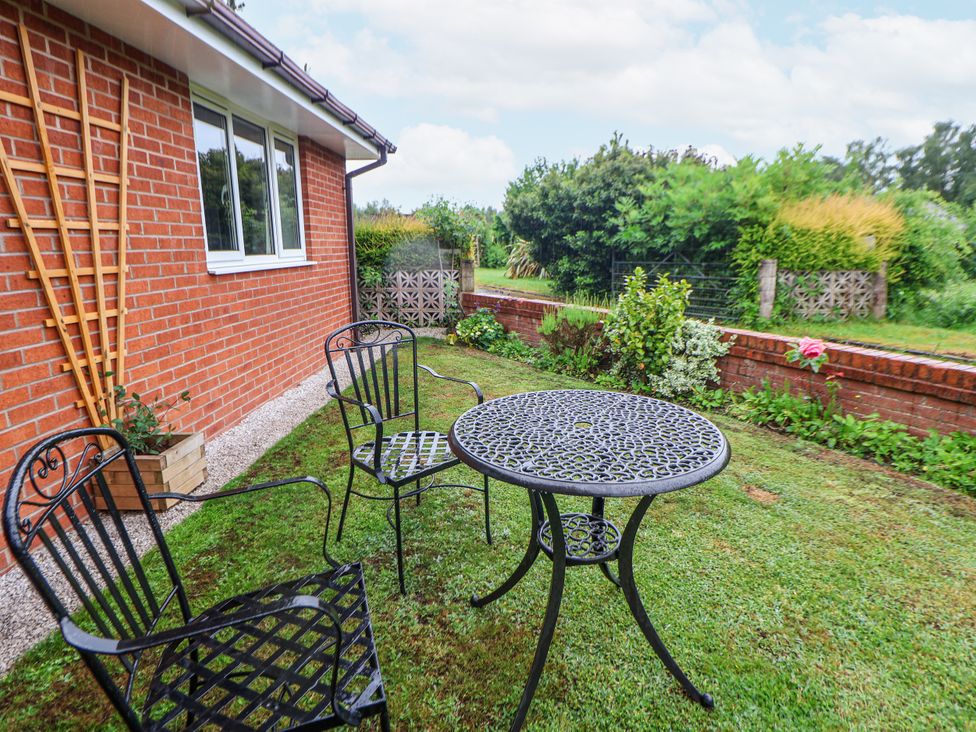 A garden with a table and chairs at 2 Mountain View in Chirk