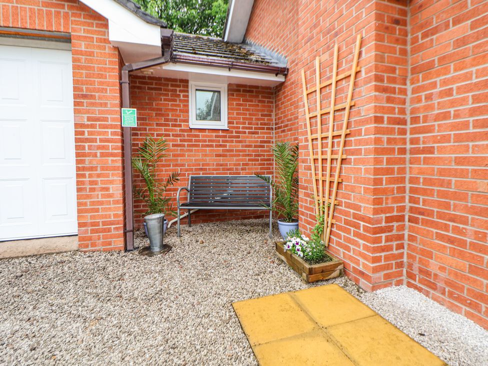 An outdoor area with a bench and plants at 2 Mountain View in Chirk