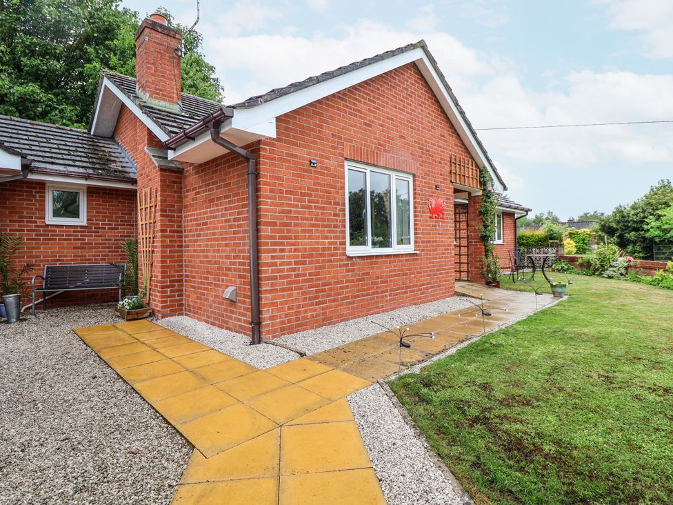 A brick house with a garden and pathway at 2 Mountain View in Chirk
