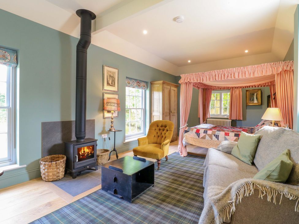 A living room with a stove and sofa at Clock Tower in Stowmarket