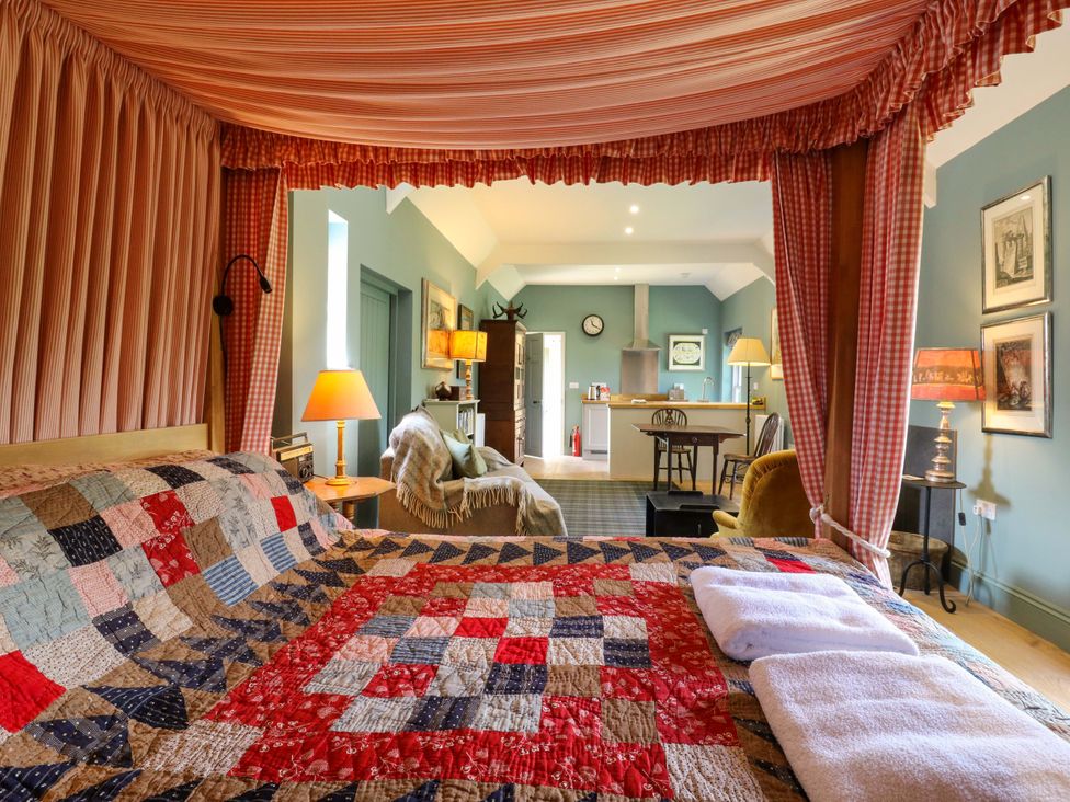 A bedroom with a quilted bed and seating area at Clock Tower in Stowmarket