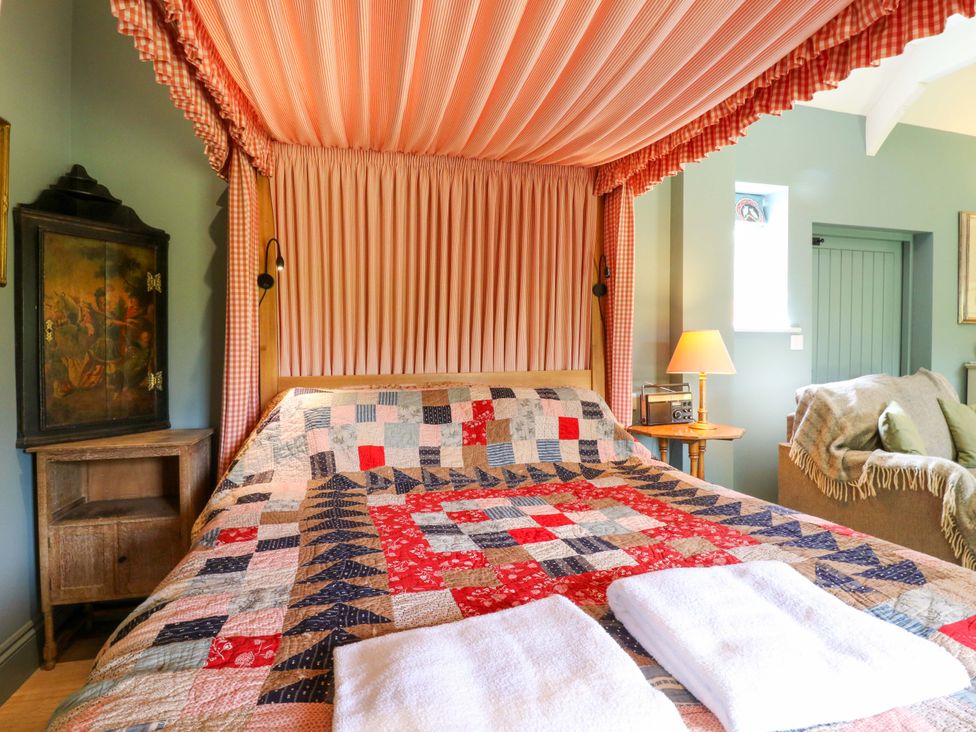 A bedroom with a patchwork quilt and lamp at Clock Tower in Stowmarket