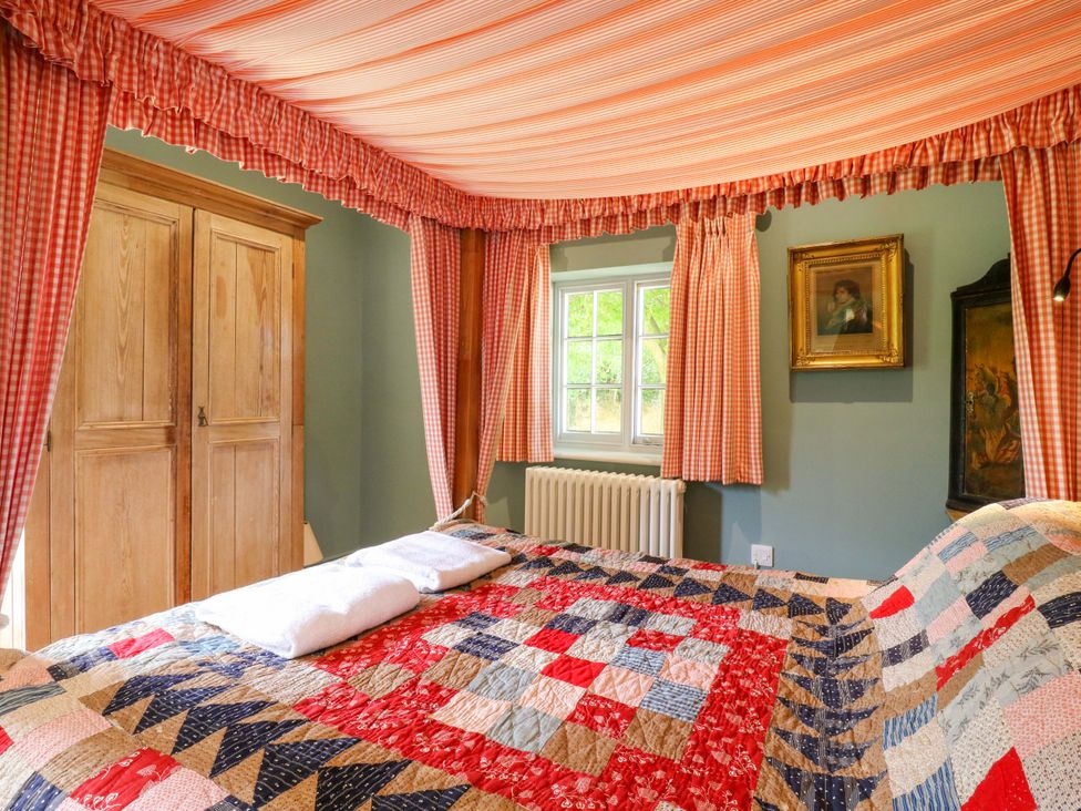 A bedroom with a quilt on the bed and wardrobe at Clock Tower in Stowmarket
