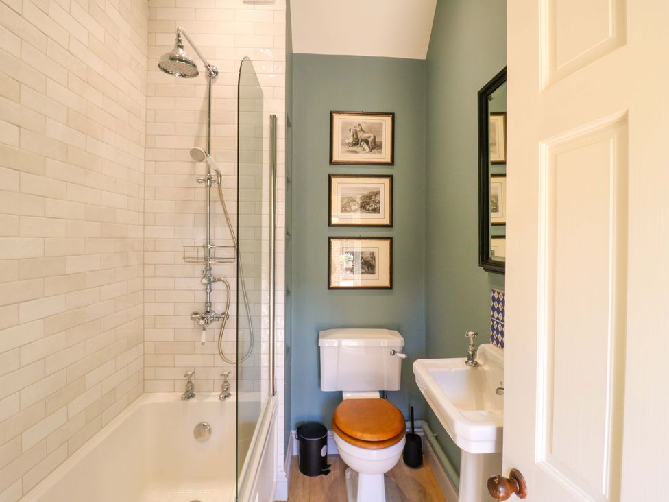 A bathroom with a shower, bathtub, toilet, and sink at Clock Tower in Stowmarket