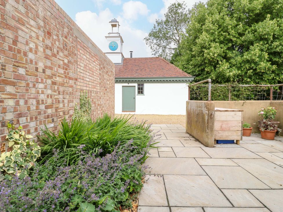 A garden area with a stone patio and plants at Clock Tower in Stowmarket