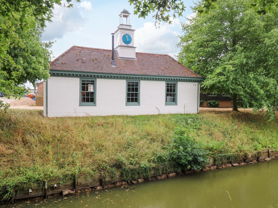 A building with a clock near a waterway at Clock Tower in Stowmarket