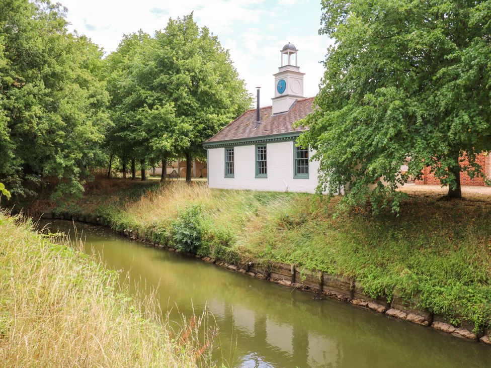 A building near a waterway with trees in the outdoor area at Clock Tower in Stowmarket