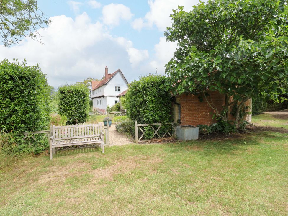 A garden with a bench and bushes at Clock Tower in Stowmarket