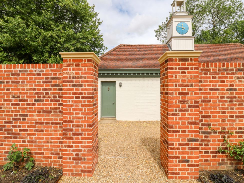 An outdoor space with a brick wall and door at Clock Tower in Stowmarket