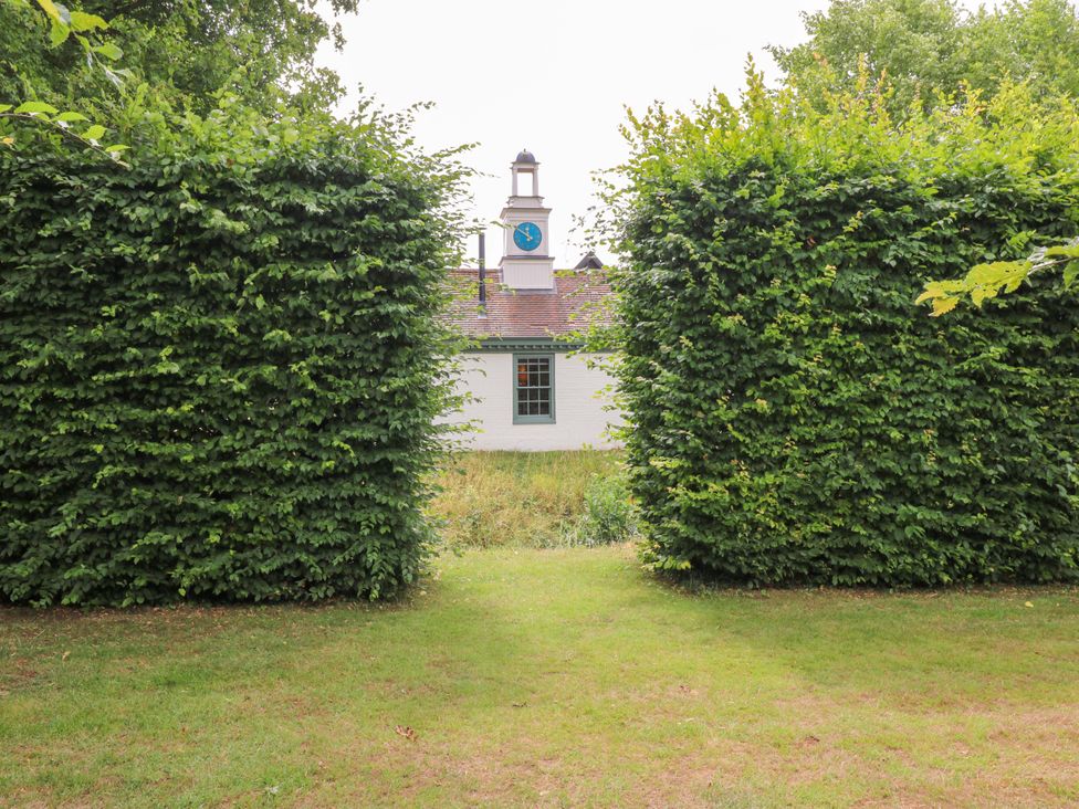 View of a building framed by hedges at Clock Tower in Stowmarket