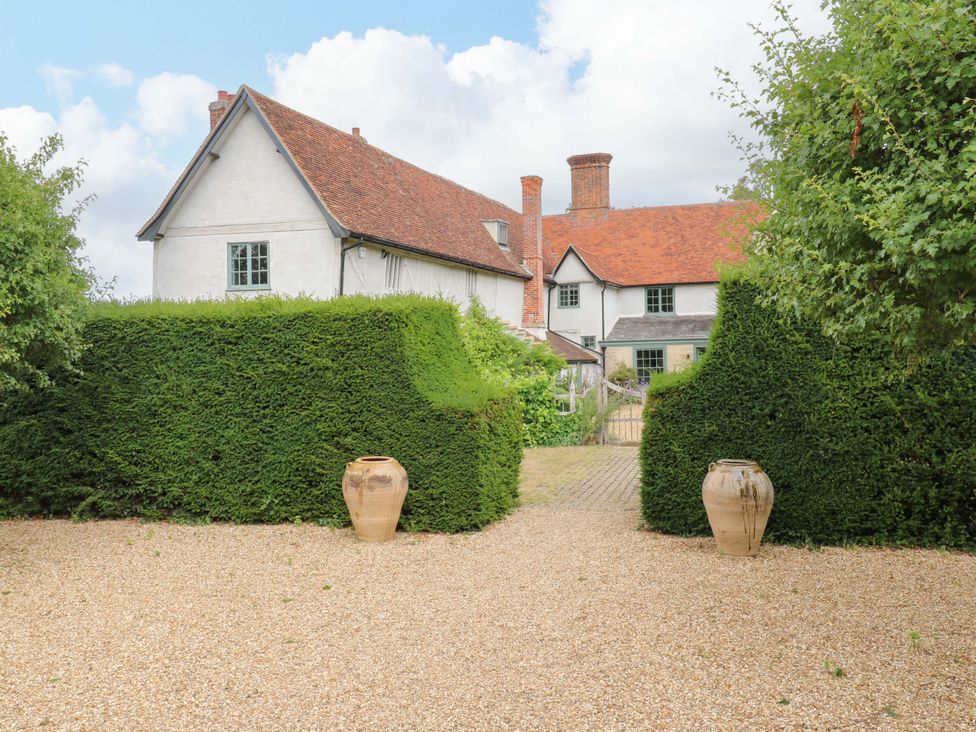 An outdoor view of a house with hedges and pots at Clock Tower in Stowmarket