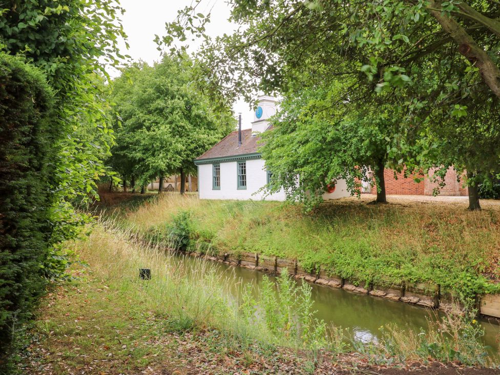 A view of a building by a canal surrounded by trees at Clock Tower in Stowmarket