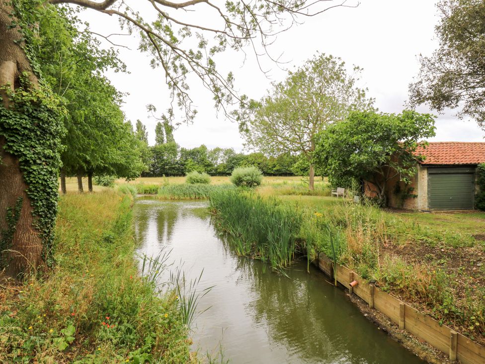 A waterway with trees and a shed at Clock Tower in Stowmarket