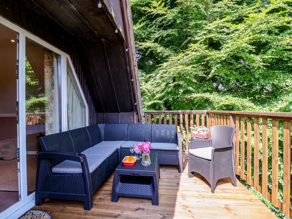 A balcony with seating and a table at Driftwood - 54 Valley Lodge, St Ann's Chapel, Cornwall