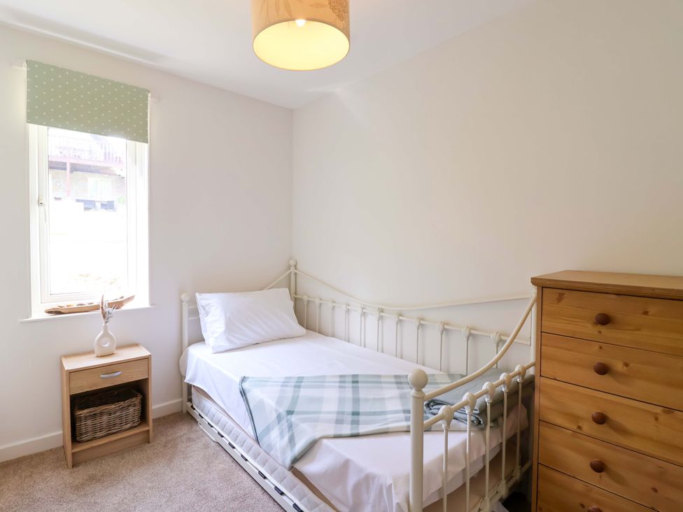 A bedroom with a single bed and a dresser at Driftwood - 54 Valley Lodge, St Ann's Chapel, Cornwall