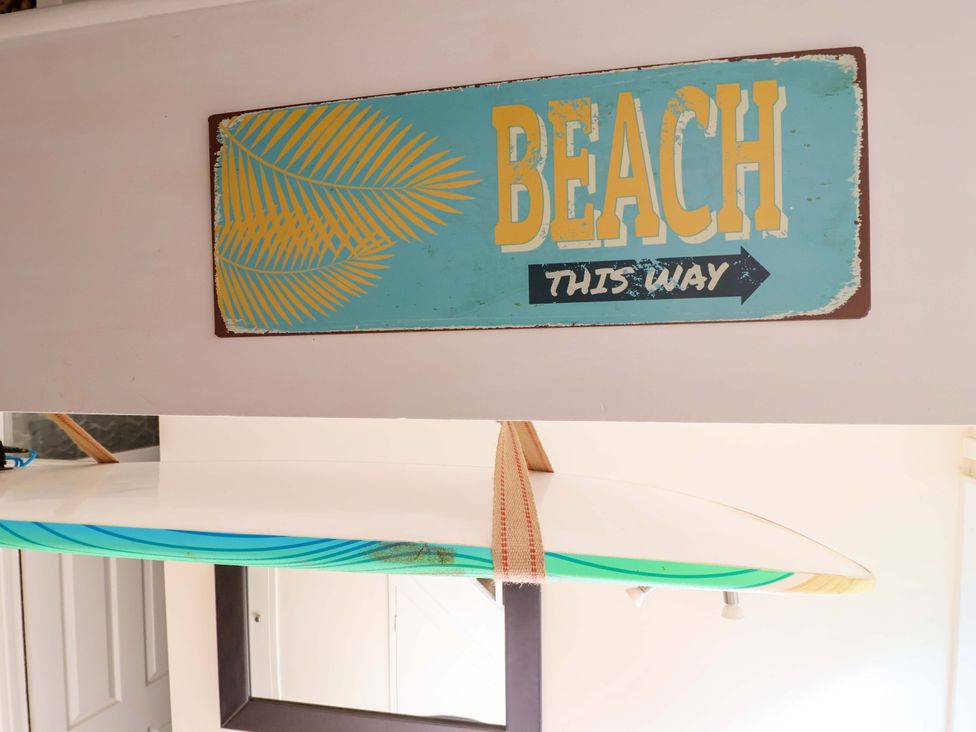 A beach sign and surfboard at Driftwood - 54 Valley Lodge St Ann's Chapel, Cornwall