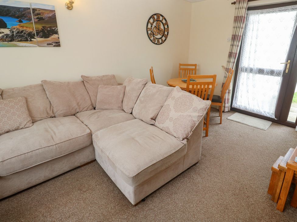 A living room with a sofa, table, and chairs at 14 Bosvigo in Ruan Major near Penhale
