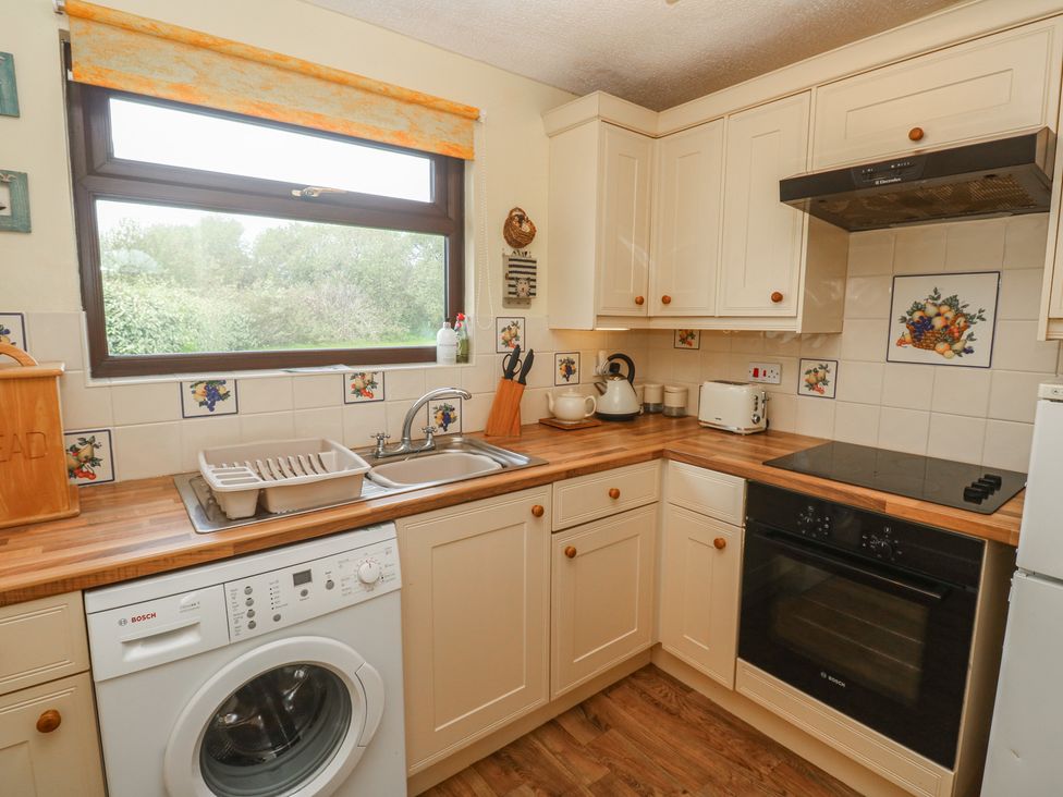 A kitchen with a washing machine and sink at 14 Bosvigo in Ruan Major near Penhale