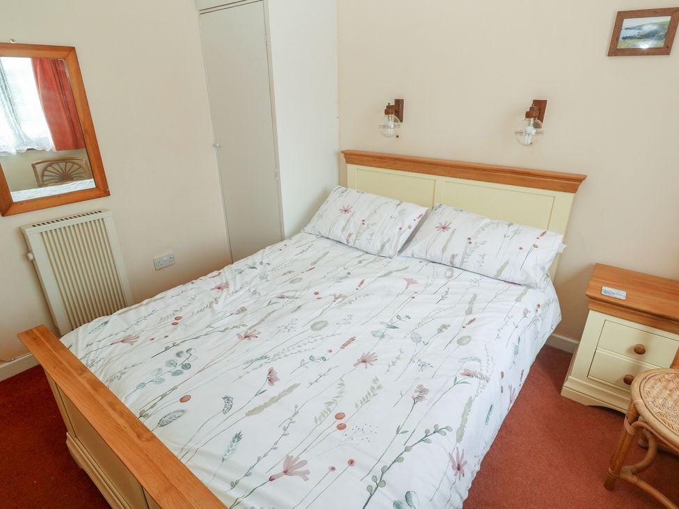 A bedroom with a bed and bedside table at 14 Bosvigo near Ruan Major
