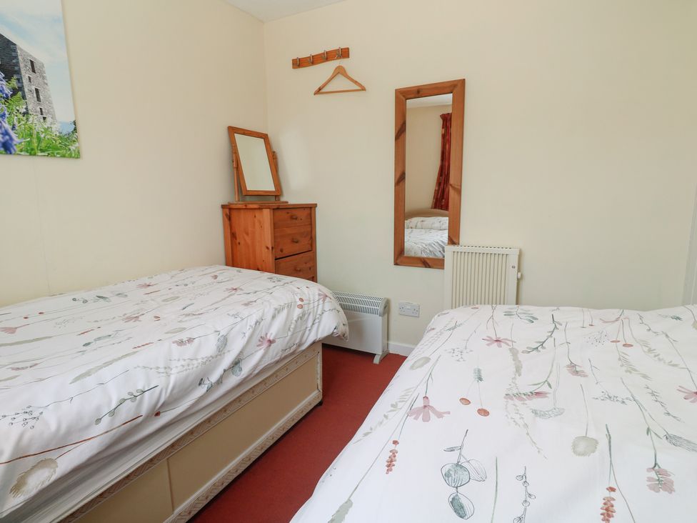A bedroom with two beds and a mirror at 14 Bosvigo near Ruan Major
