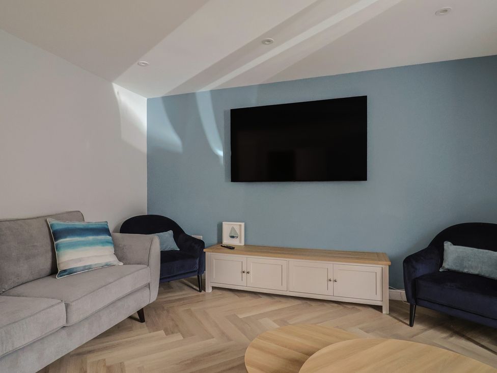 A living room with a television and seating at Wagtail Cottage Lyme Regis