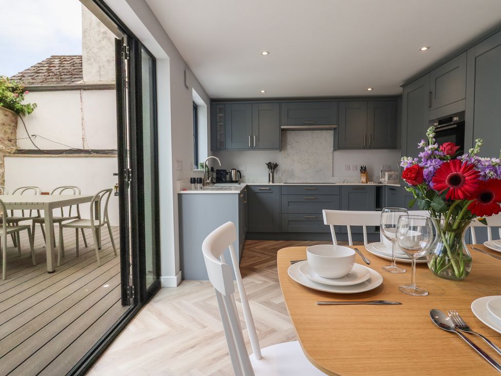 A kitchen with dining table and flowers at Wagtail Cottage in Lyme Regis