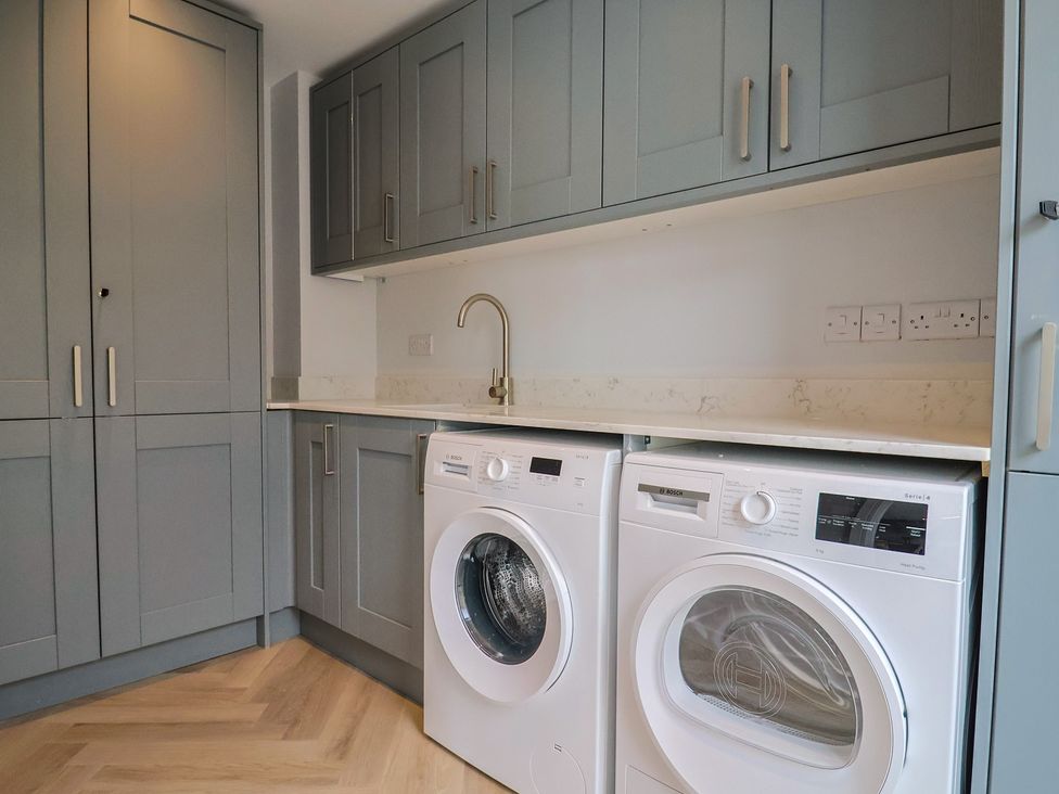 A laundry room with a washing machine and dryer at Wagtail Cottage in Lyme Regis