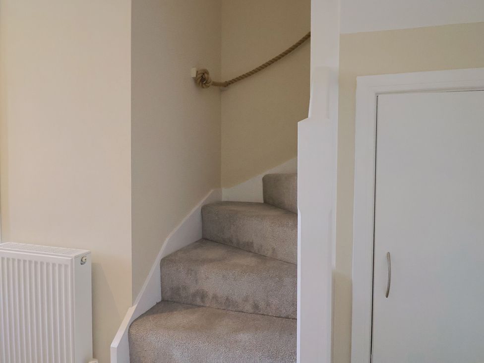 A staircase with carpet and a door at Wagtail Cottage in Lyme Regis