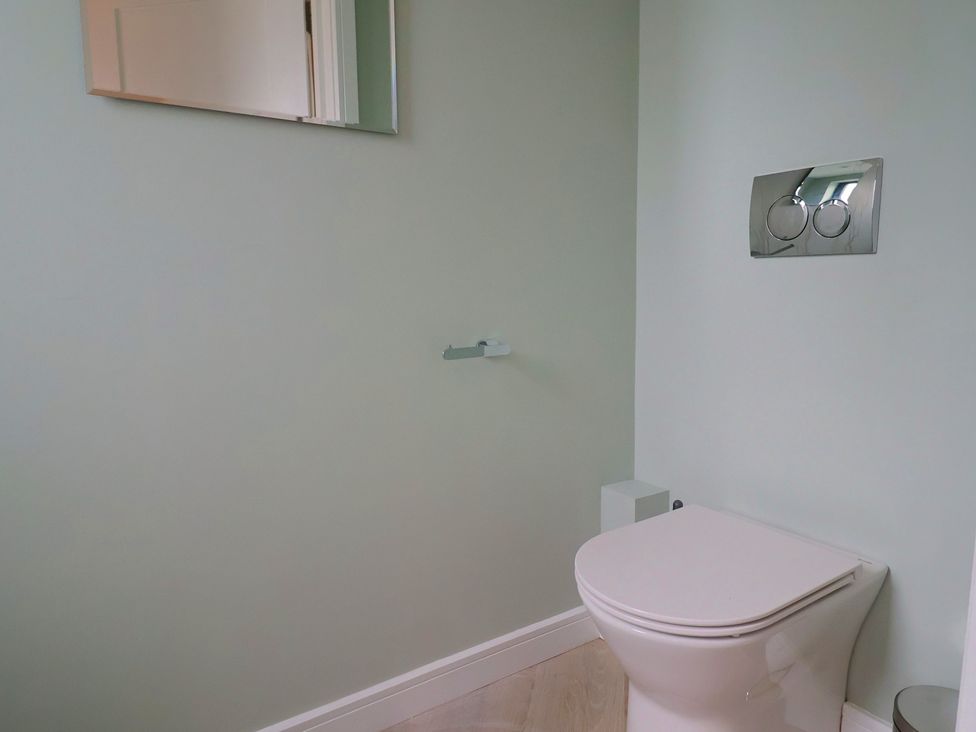 A bathroom with a toilet and a mirror at Wagtail Cottage in Lyme Regis