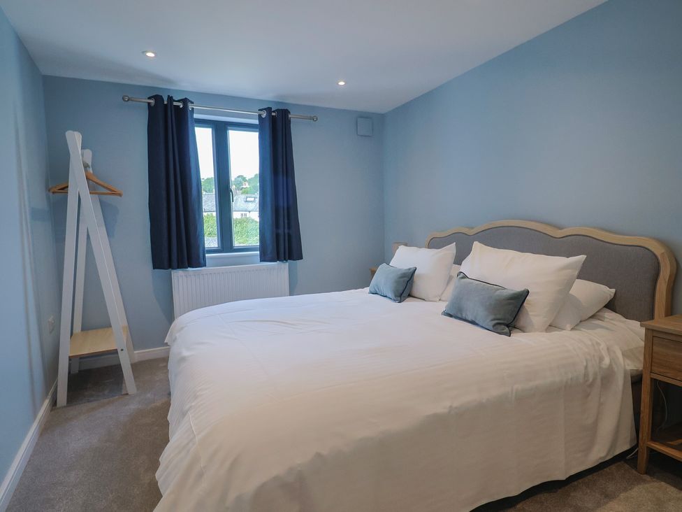 A bedroom with a bed and window at Wagtail Cottage in Lyme Regis