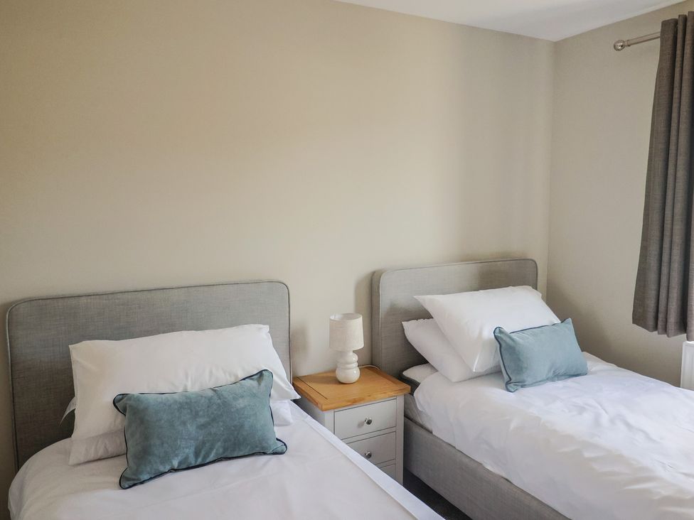 A bedroom with two single beds and a lamp at Wagtail Cottage in Lyme Regis