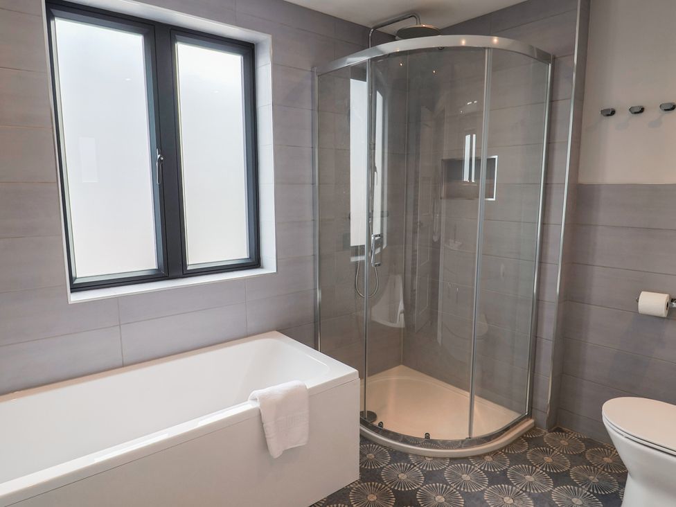 A bathroom with a bathtub and shower at Wagtail Cottage in Lyme Regis