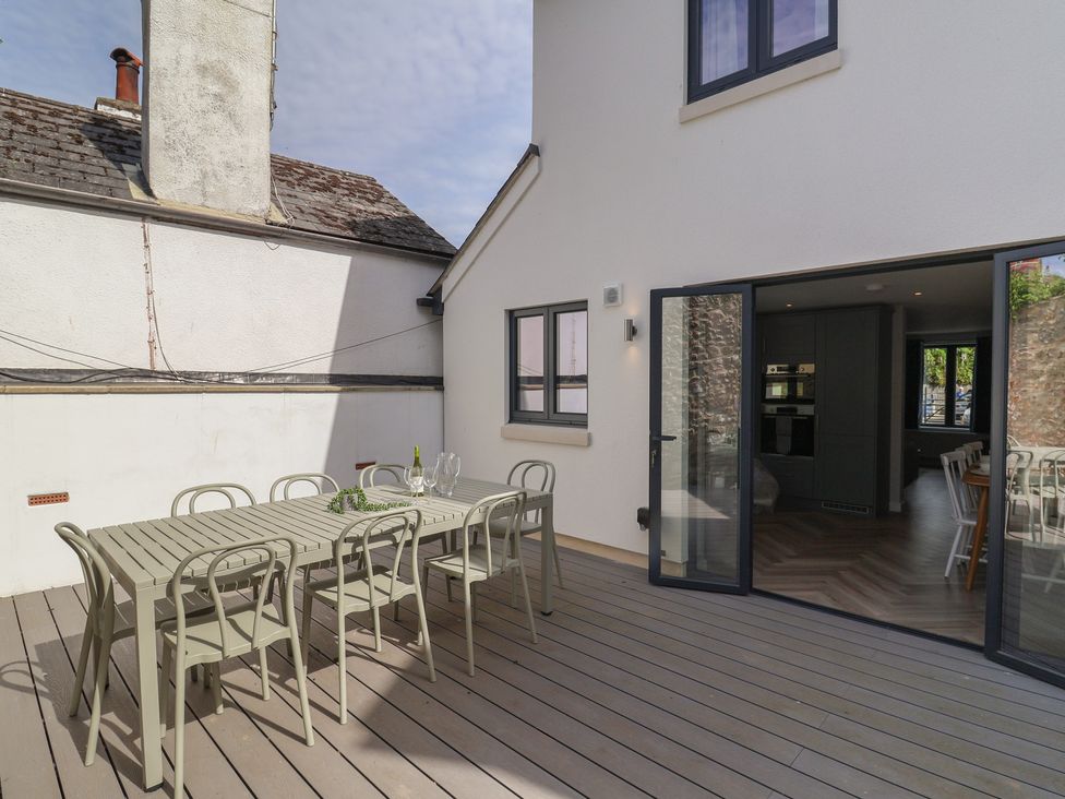 An outdoor dining area with a table and chairs at Wagtail Cottage in Lyme Regis