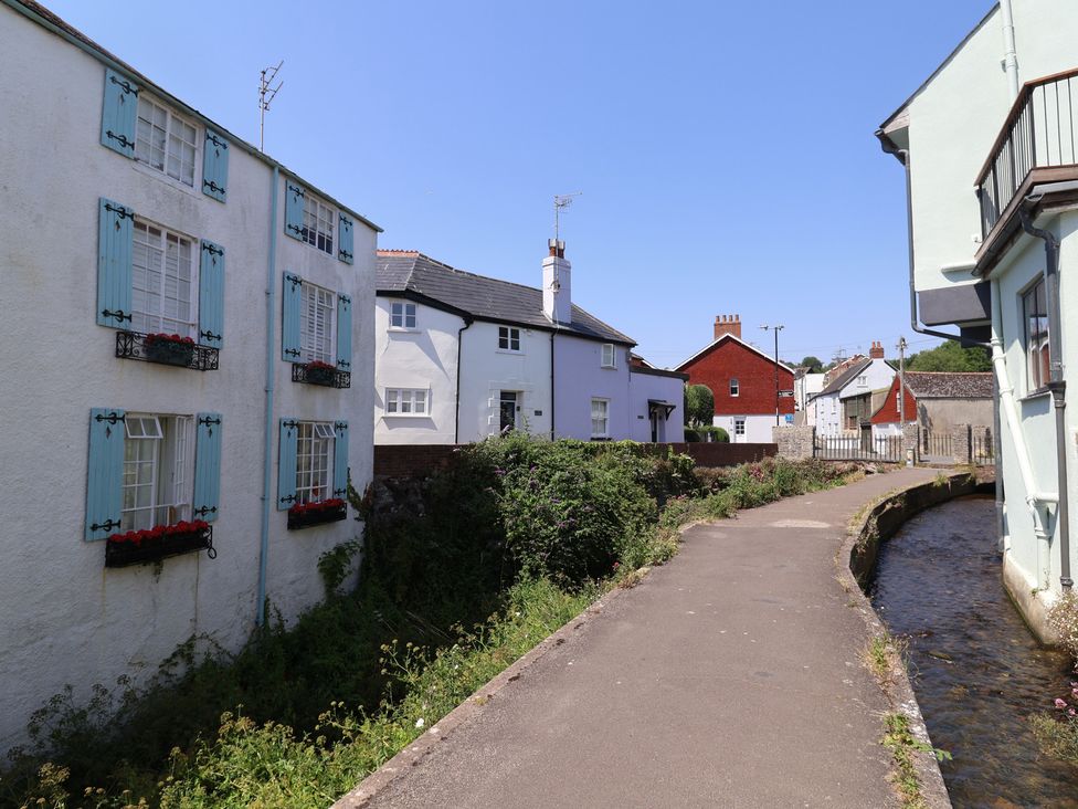 A view of houses along a pathway next to a stream at Wagtail Cottage in Lyme Regis