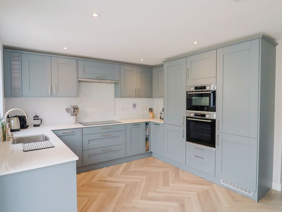 A kitchen with cabinets and appliances at Wagtail Cottage in Lyme Regis