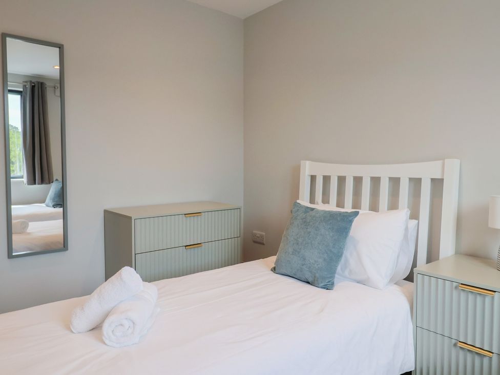 A bedroom with a bed and nightstands at Wagtail Cottage in Lyme Regis