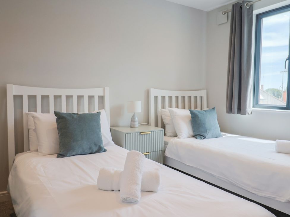 A bedroom with two single beds and a window at Wagtail Cottage in Lyme Regis
