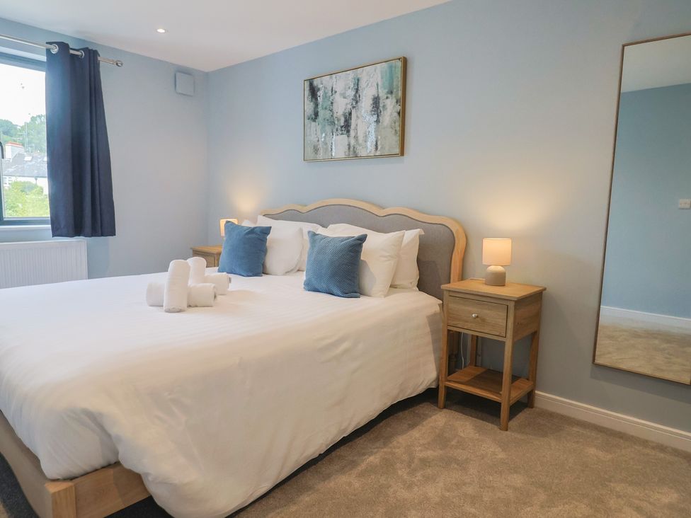A bedroom with a bed and nightstand at Wagtail Cottage in Lyme Regis