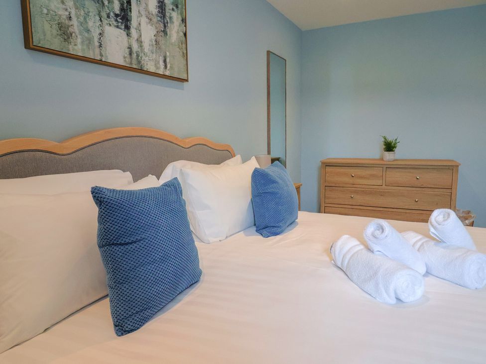 A bedroom with bed and towels at Wagtail Cottage in Lyme Regis